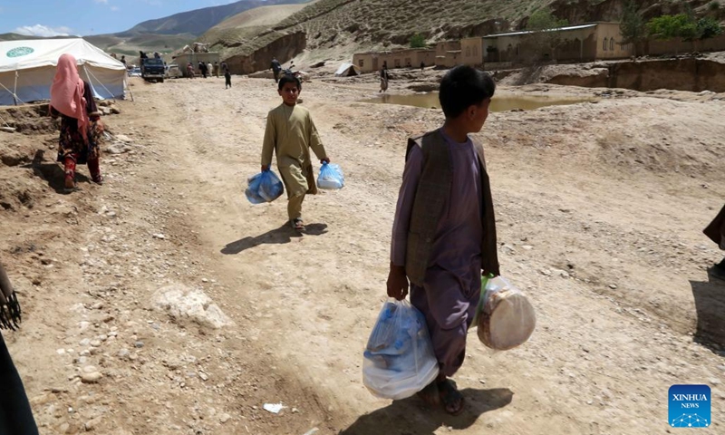 Children carry flood-relief materials in Borka District, north Afghanistan's Baghlan Province, May 12, 2024. About 40,000 children have lost their homes in north Afghanistan's Baghlan province as heavy downpours and floods lashed the province and other regions on Friday, global charity Save the Children said Monday.(Photo: Xinhua)