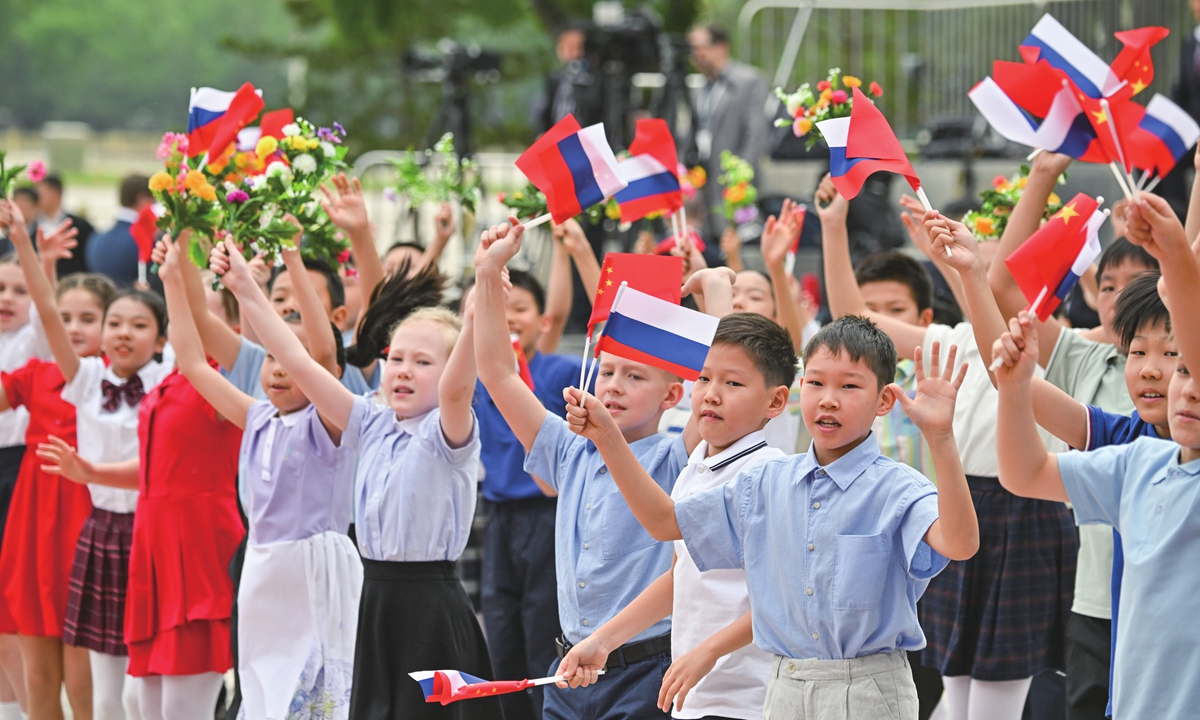 Children wave Chinese and Russian flags before a welcome ceremony for Russian President Vladimir Putin outside the Great Hall of the People in Beijing on May 16, 2024 Photo: VCG