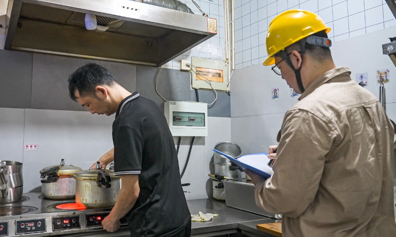 Marketing service personnel from the State Grid Changzhou Power Supply Company inspect power usage for catering businesses along Dongcheng Street, Jintan district, Changzhou on May 17. Photo: Xu Duo