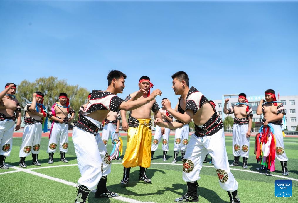 Teacher Han Jun (C) instructs students on Mongolian wrestling at a middle school in Fuxin Mongolian Autonomous County, northeast China's Liaoning Province, May 15, 2024. Fuxin has stepped up efforts in protection and inheritance of traditional Mongolian ethnic culture by offering students various lessons such as horse-head fiddle and Mongolian dance, etc. to help bring new vitality to traditional ethnic culture.(Photo: Xinhua)