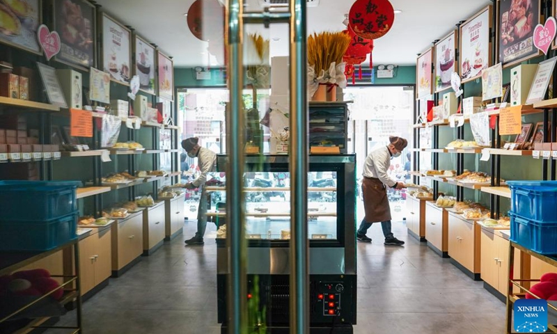 Fu Fu takes packaged bread to shelves at Amity Bakery in Nanjing, east China's Jiangsu Province, May 15, 2024. Located in the Xinjiekou commercial area in dontown Nanjing, Amity Bakery is not only known for its delicious bread and pastries but also for its remarkable workforce, two-thirds of whom are individuals with intellectual disabilities.(Photo: Xinhua)