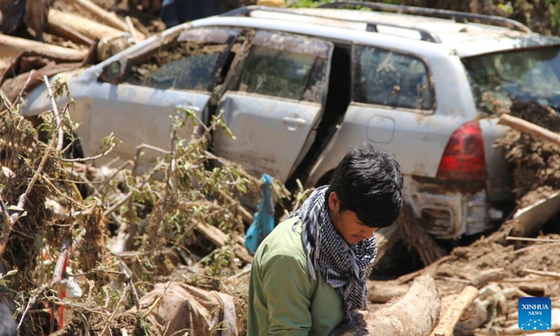A man walks past a car damaged by flood in Firoz Koh in west Afghanistan's Ghor province, May 18, 2024. At least 50 people have been killed, with 10 others missing, in the past 24 hours in west Afghanistan's Ghor Province, a local official said Saturday. Afghanistan has been experiencing heavy rains and floods in the past month, causing casualties and property damage. Photo: Xinhua