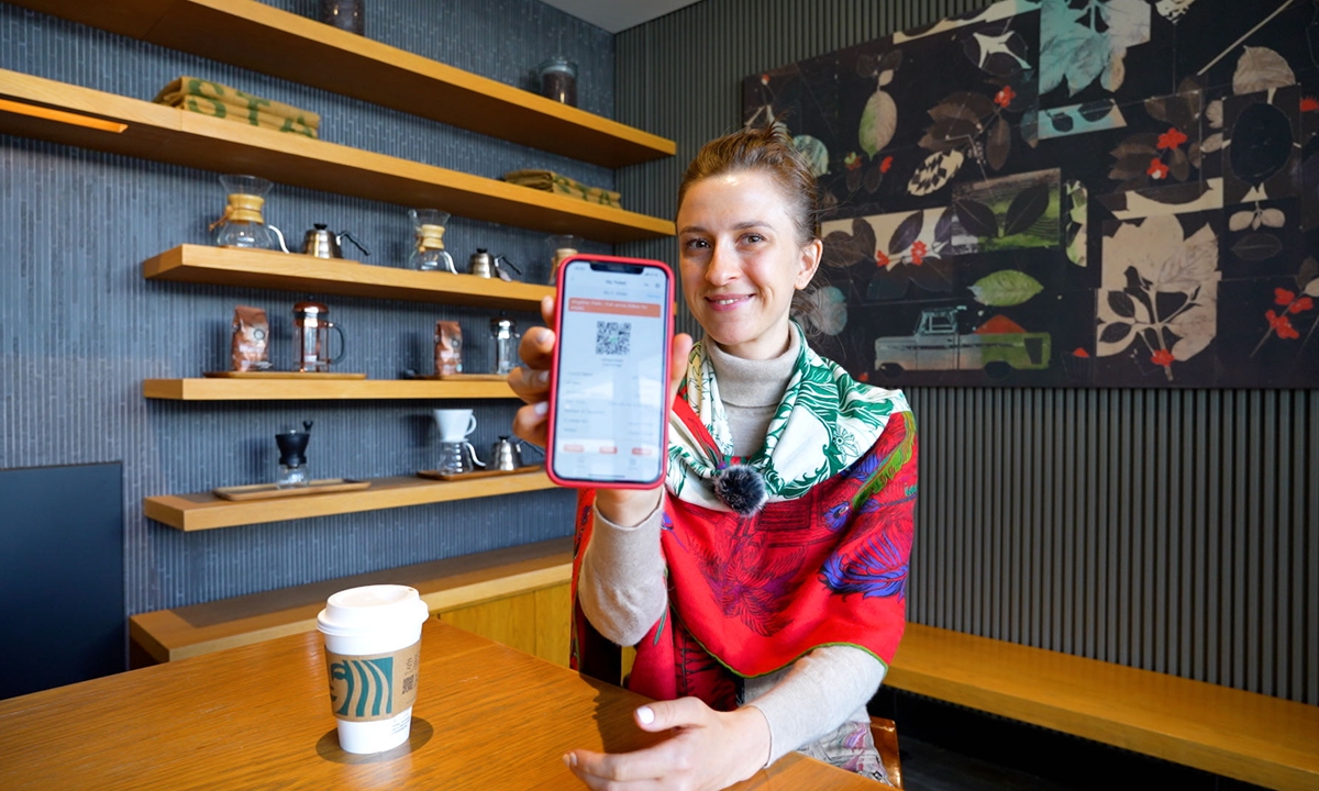 A foreign tourist books park tickets with a mobile app in Beijing. Photo: Kang Jie