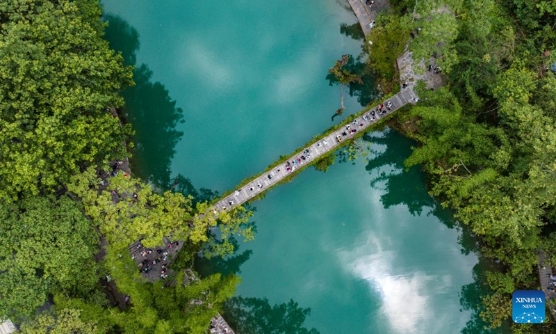 An aerial drone photo taken on May 16, 2024 shows tourists visiting Xiaoqikong scenic area in Libo County, southwest China's Guizhou Province. Situated on the steep mountainside of Guizhou, Libo County has spectacular views in abundance and has seen a boom in tourism in recent years. Photo: Xinhua