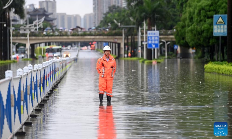 A sanitary worker stands on a waterlogged street to stop people from passing in Nanning, south China's Guangxi Zhuang Autonomous Region, May 19, 2024. Heavy rain hit Nanning on Saturday. Photo: Xinhua
