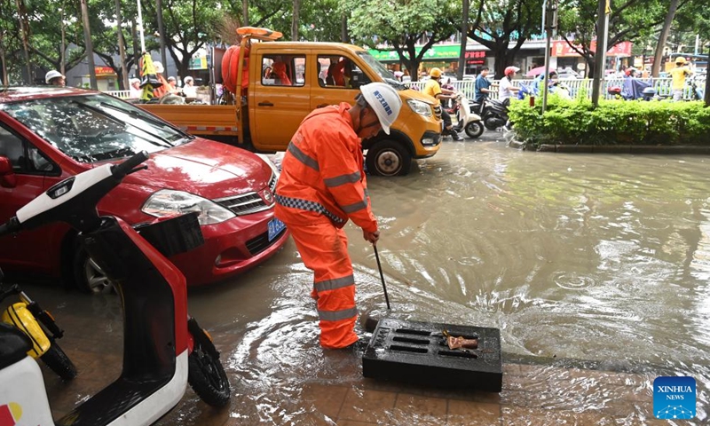 A sanitary worker cleans up sewerage facilities on a street in Nanning, south China's Guangxi Zhuang Autonomous Region, May 19, 2024. Heavy rain hit Nanning on Saturday. Photo: Xinhua