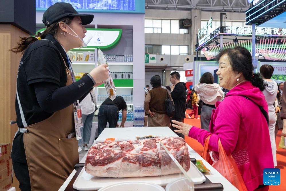 An exhibitor introduces beef to a visitor during the eighth China-Russia Expo in Harbin, northeast China's Heilongjiang Province, May 20, 2024. Over 5,000 overseas buyers registered at the expo and representatives from 44 countries and regions participated in the expo. The exhibition area spans 388,000 square meters, showcasing more than 5,000 products in over 20 major categories from 10 sectors.(Photo: Xinhua)