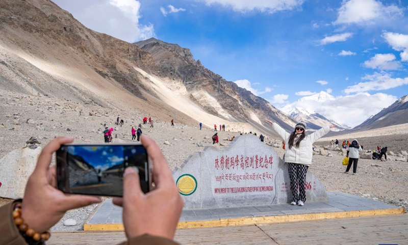 Tourists line up to take photos with the monument to the elevation survey of Mount Qomolangma in southwest China's Xizang Autonomous Region, May 24, 2024. The Mount Qomolangma National Park has entered peak tourism season. From Jan. 1 to May 20 this year, the Mount Qomolangma scenic spot has received about 136,000 tourists. (Photo:Xinhua)