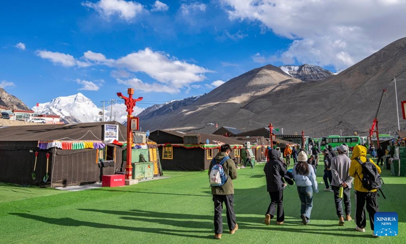 Tourists walk in a base camp of Mount Qomolangma in southwest China's Xizang Autonomous Region, May 24, 2024. The Mount Qomolangma National Park has entered peak tourism season. From Jan. 1 to May 20 this year, the Mount Qomolangma scenic spot has received about 136,000 tourists. (Photo:Xinhua)