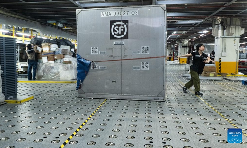 Staff members sort parcels at the transfer center of the Ezhou Huahu Airport in Ezhou, central China's Hubei Province, May 25, 2024. The Ezhou Huahu Airport, an all-cargo hub airport starting operations in July 2022, is now running 48 domestic routes and 17 international routes. The airport owns a 750,000-square meter cargo transfer center with parcel sorting lines adding up to 52 kilometers, and its international throughput has exceeded 80,000 tonnes. (Photo:Xinhua)