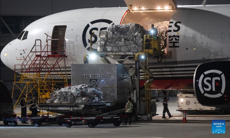 Staff members load the cargo onto an airplane at the Ezhou Huahu Airport in Ezhou, central China's Hubei Province, May 25, 2024. The Ezhou Huahu Airport, an all-cargo hub airport starting operations in July 2022, is now running 48 domestic routes and 17 international routes. The airport owns a 750,000-square meter cargo transfer center with parcel sorting lines adding up to 52 kilometers, and its international throughput has exceeded 80,000 tonnes. (Photo:Xinhua)