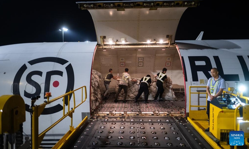 Staff members load the cargo onto an airplane at the Ezhou Huahu Airport in Ezhou, central China's Hubei Province, May 25, 2024. The Ezhou Huahu Airport, an all-cargo hub airport starting operations in July 2022, is now running 48 domestic routes and 17 international routes. The airport owns a 750,000-square meter cargo transfer center with parcel sorting lines adding up to 52 kilometers, and its international throughput has exceeded 80,000 tonnes. (Photo:Xinhua)