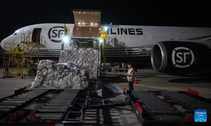 Staff members load the cargo onto an airplane at the Ezhou Huahu Airport in Ezhou, central China's Hubei Province, May 25, 2024. The Ezhou Huahu Airport, an all-cargo hub airport starting operations in July 2022, is now running 48 domestic routes and 17 international routes. The airport owns a 750,000-square meter cargo transfer center with parcel sorting lines adding up to 52 kilometers, and its international throughput has exceeded 80,000 tonnes. (Photo:Xinhua)