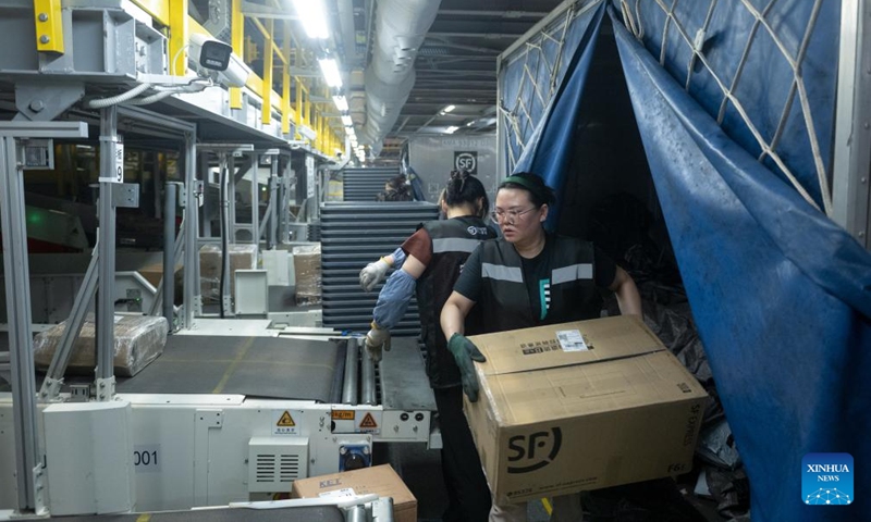 Staff members sort parcels at the transfer center of the Ezhou Huahu Airport in Ezhou, central China's Hubei Province, May 25, 2024. The Ezhou Huahu Airport, an all-cargo hub airport starting operations in July 2022, is now running 48 domestic routes and 17 international routes. The airport owns a 750,000-square meter cargo transfer center with parcel sorting lines adding up to 52 kilometers, and its international throughput has exceeded 80,000 tonnes. (Photo:Xinhua)