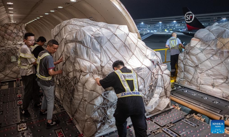 Staff members load the cargo onto an airplane at the Ezhou Huahu Airport in Ezhou, central China's Hubei Province, May 25, 2024. The Ezhou Huahu Airport, an all-cargo hub airport starting operations in July 2022, is now running 48 domestic routes and 17 international routes. The airport owns a 750,000-square meter cargo transfer center with parcel sorting lines adding up to 52 kilometers, and its international throughput has exceeded 80,000 tonnes. (Photo:Xinhua)