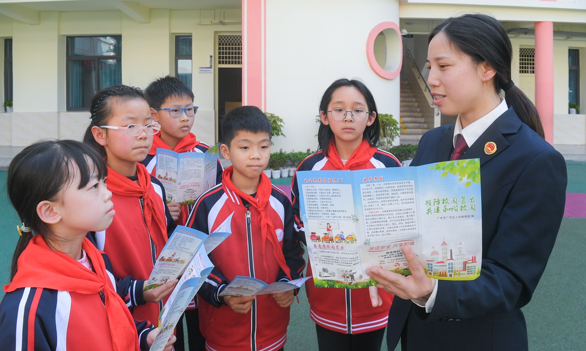 A police officer from the People's Procuratorate of Guang'an district in Guang'an, Southwest China's Sichuan Province, explains to students from a primary school how to resist school bullying on March 21, 2024. Photo: VCG 