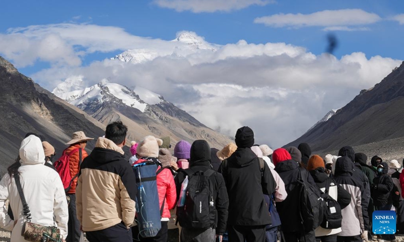 Tourists line up to take photos at the Mount Qomolangma base camp for tourists in Zhaxizom Township of Tingri County in Xigaze City, southwest China's Xizang Autonomous Region, May 24, 2024. The Mount Qomolangma National Park has entered peak tourism season. In 2023, the scenic spot had received about 464,000 tourists, and saw its ticket revenue totaling 110 million yuan (about 15.2 million U.S. dollars). (Photo: Xinhua)