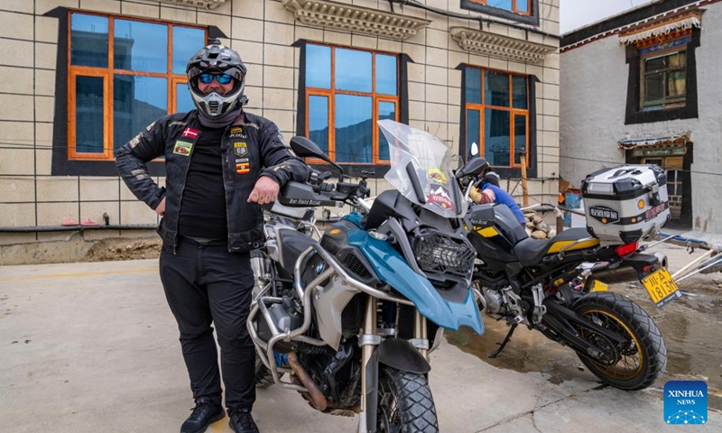 Mike Thomsen, a tourist from Denmark, poses for photos with his motorcycle at the foot of Mount Qomolangma in Zhaxizom Township of Tingri County in Xigaze City, southwest China's Xizang Autonomous Region, May 23, 2024. The Mount Qomolangma National Park has entered peak tourism season. In 2023, the scenic spot had received about 464,000 tourists, and saw its ticket revenue totaling 110 million yuan (about 15.2 million U.S. dollars). (Photo: Xinhua)