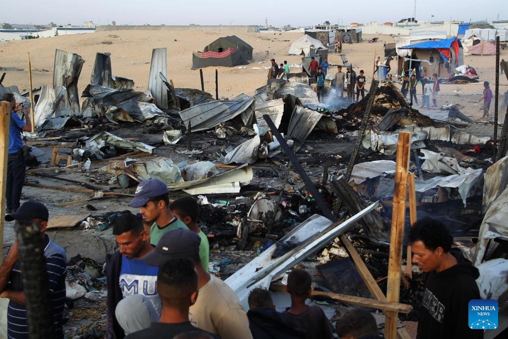 People are seen at the site of an Israeli strike on a camp for displaced people in Rafah in the southern Gaza Strip, May 27, 2024. At least 40 people were killed and some others injured on Sunday evening in Israel's bombing of tents in northwestern Rafah, the southernmost city of the Gaza Strip, the Palestinian official news agency WAFA reported.(Photo: Xinhua)
