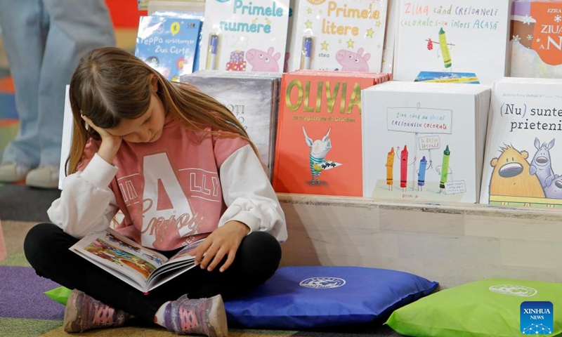 A child reads a book during the opening day of the 17th edition of Bookfest, an international book fair, in Bucharest, Romania, May 29, 2024. The five-day event attracts about 200 exhibitors.(Photo: Xinhua)