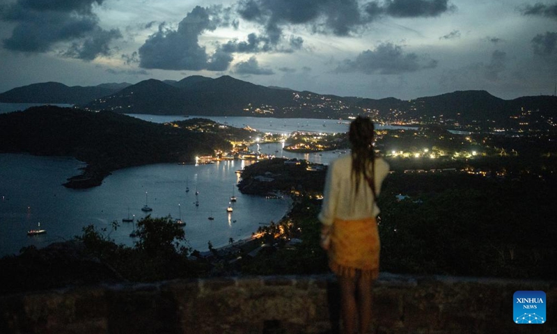 A tourist enjoys night view at Shirley Heights in Antigua and Barbuda, May 29, 2024. (Xinhua/Li Muzi)