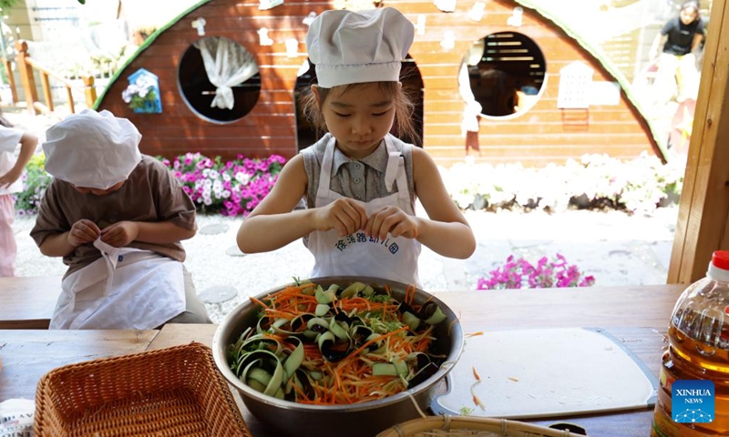 Children prepare food at Xuhai Road Kindergarten in Xuzhou, east China's Jiangsu Province, May 23, 2024. In the city of Xuzhou, Xuhai Road Kindergarten produces an unconventional symphony featuring the rhythmic chopping of vegetables, the comforting sizzle of baking buns, and the gentle grind of the soybean milk milling process. (Photo: Xinhua)