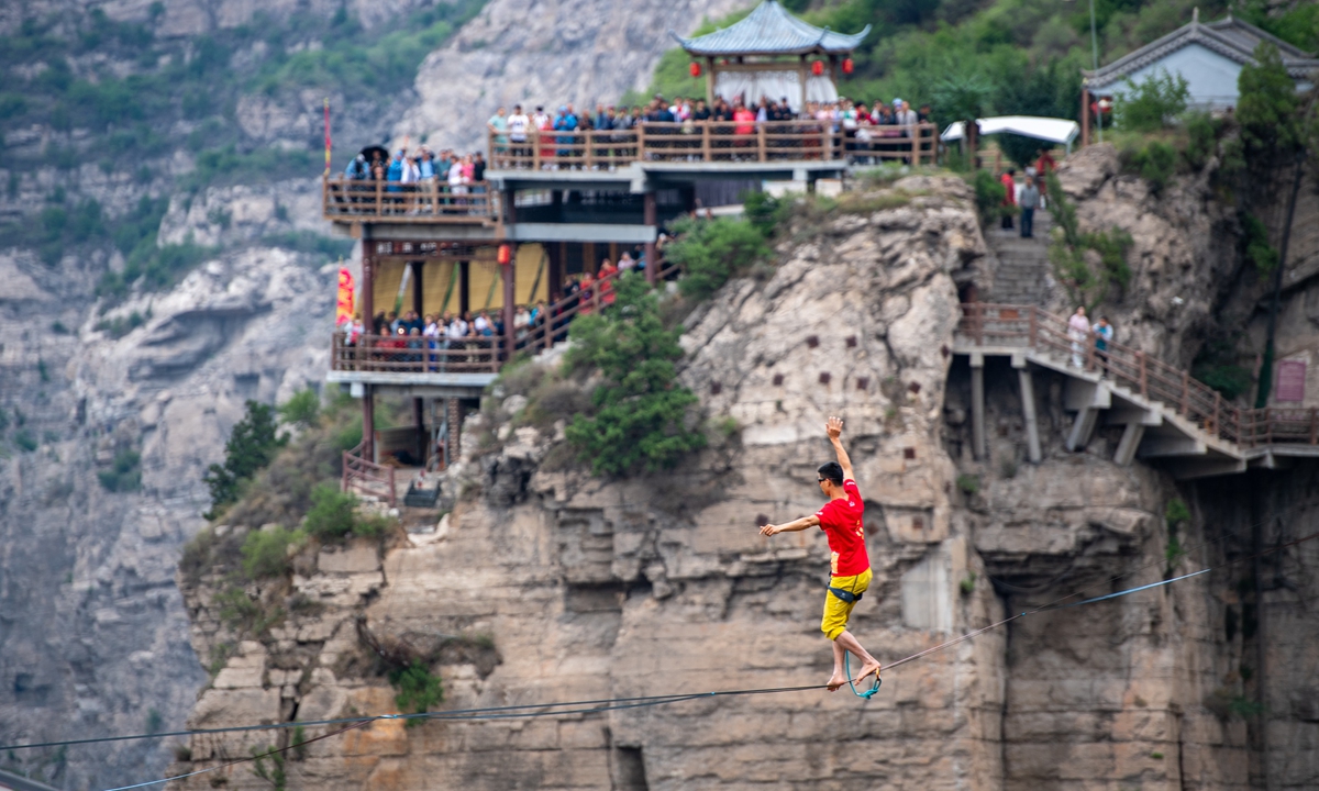 Shi Hailin, known as China's best high-altitude slackline walker, crosses the Yellow River on a 569-meter long and 186-meter high slackline, from Yuncheng, North China's Shanxi Province, to Weinan, Northwest China's Shaanxi Province, on June 2, 2024. After successfully completing the challenge, Shi beat his own record for the longest high-altitude slackline walk in Asia of 520 meters.