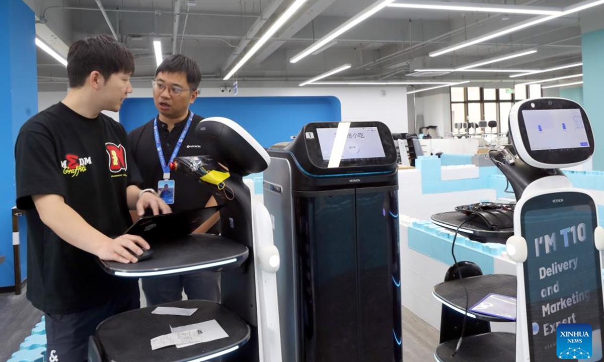 Tang Xuanlai (R) and his colleague work at a robot testing field of Keenon Robotics in Shanghai, east China, May 30, 2024. (Photo: Xinhua)