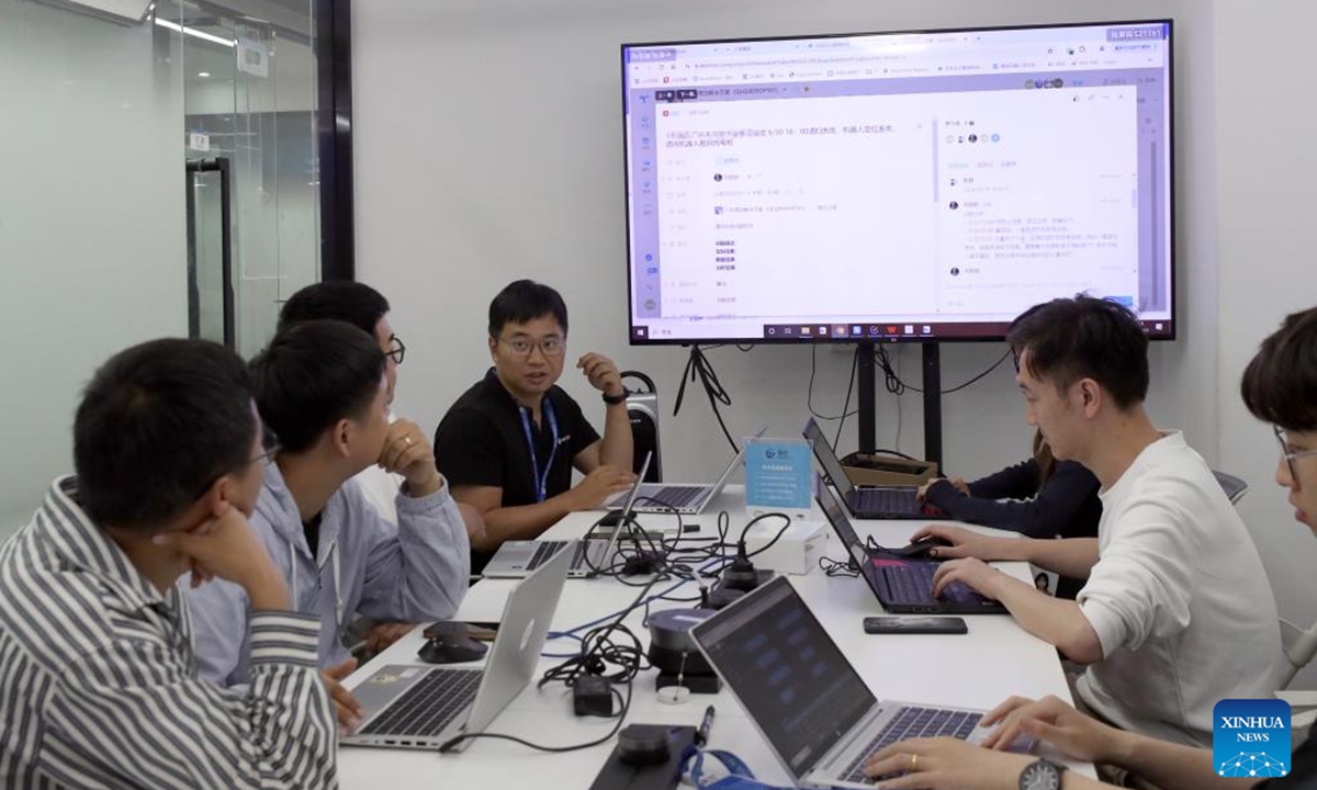 Tang Xuanlai (4th L) and his colleagues talk about problems they encountered during the tests of newly developed robots at Keenon Robotics in Shanghai, east China, May 31, 2024. (Photo: Xinhua)