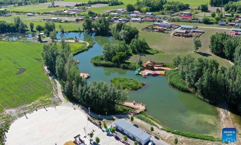 An aerial drone photo taken on May 30, 2024 shows an agro-tourism area in Emin County, Tacheng Prefecture, northwest China's Xinjiang Uygur Autonomous Region. Xinjiang in northwest China has entered its peak tourism season recently. Emin County, located near the China-Kazakhstan border, is a popular tourist destination which provides various rural tour routes and cultural events. (Photo: Xinhua)