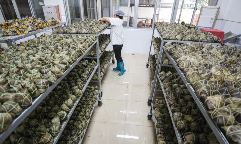 A worker arranges Zongzi at a food company in Ding'an County, south China's Hainan Province, June 2, 2024. This year's Dragon Boat Festival falls on June 10, when Zongzi, a pyramid-shaped dumpling made of glutinous rice wrapped in bamboo or reed leaves for this occasion, will be in great demand. Zongzi processing factories in Ding'an County are in a buzz to get these delis ready. (Photo: Xinhua)