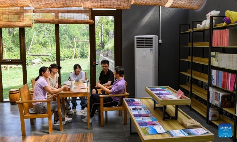 Teachers and students from Beijing Institute of Petrochemical Technology discuss rural cultural tourism at a reading room in Shixia Village in Yanqing District of Beijing, capital of China, May 31, 2024. Shixia Village in Yanqing District of Beijing was first built in the Ming Dynasty (1368-1644) and was once an important pass in the north of Juyongguan section of the Great Wall. (Photo: Xinhua)