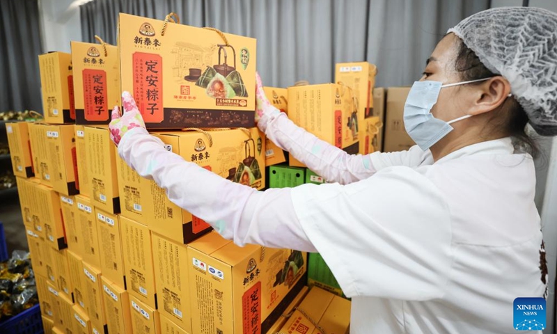 A worker arranges Zongzi gift boxes at a food company in Ding'an County, south China's Hainan Province, June 2, 2024. (Photo: Xinhua)
