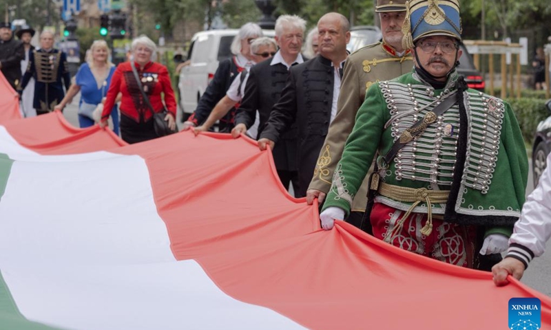 People march with a 1,848-meter-long Hungarian flag to celebrate the Day of National Unity in Budapest, Hungary, on June 2, 2024. June 4 marks Hungary's Day of National Unity(Photo: Xinhua)