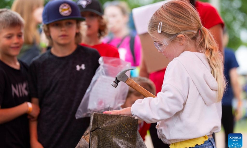 A girl competes during the Nail Driving & Log Saw Competition at the Brooklin Spring Fair in Brooklin, Ontario, Canada, on June 2, 2024.(Photo: Xinhua)
