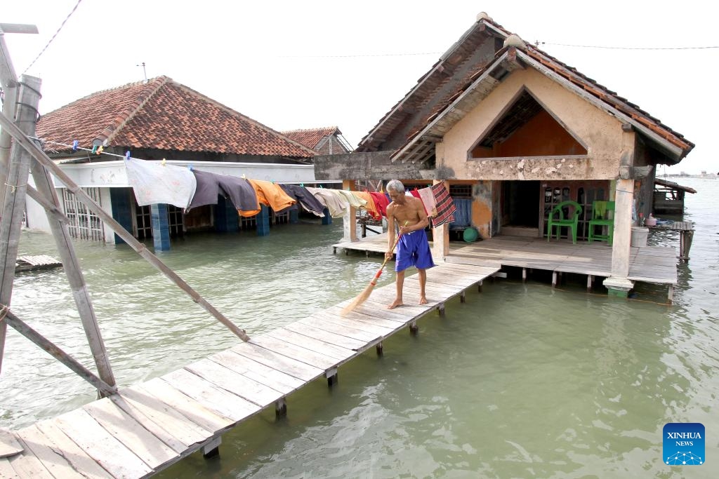 A man cleans his living area surrounded by water in Timbulsloko village in Demak, Central Java, Indonesia, June 3, 2024. Rising sea levels and subsidence of the land surface have resulted in some villages being surrounded by sea water.(Photo: Xinhua)