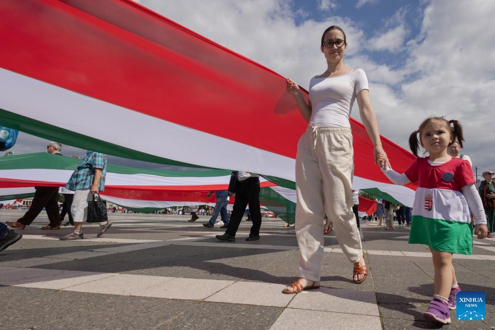 People march with a 1,848-meter-long Hungarian flag to celebrate the Day of National Unity in Budapest, Hungary, on June 2, 2024. June 4 marks Hungary's Day of National Unity.(Photo: Xinhua)
