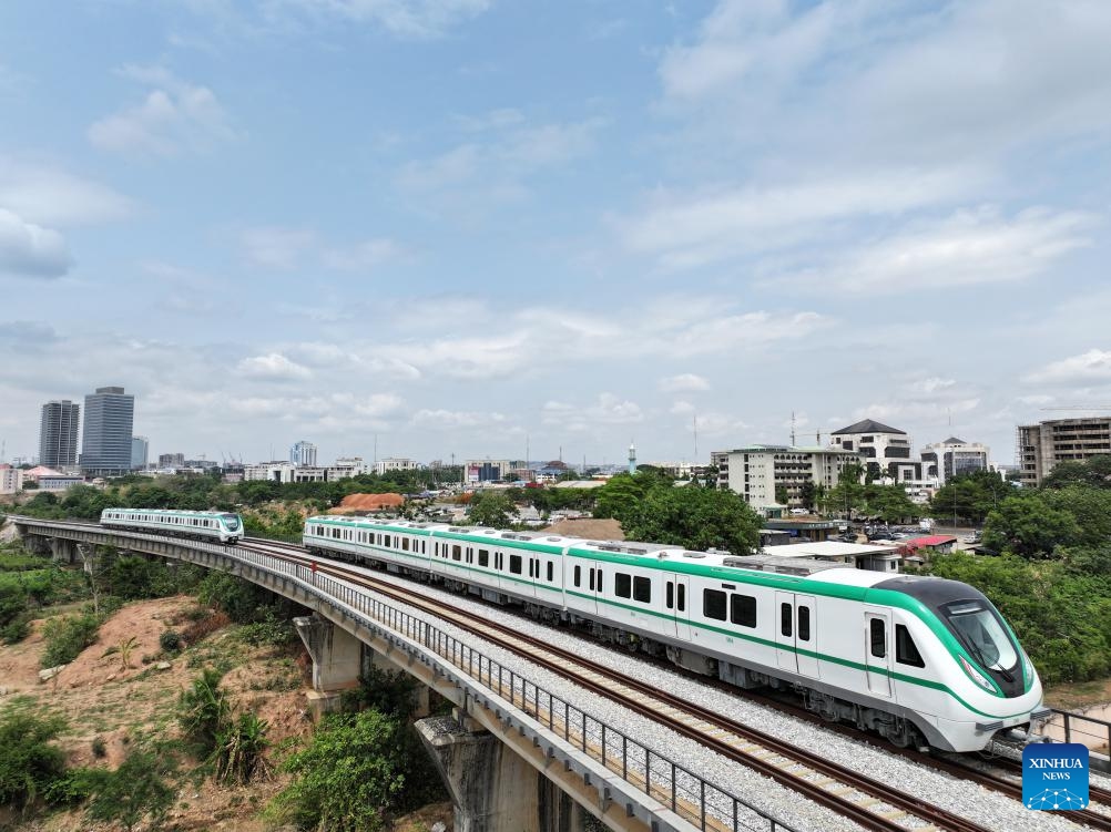 Chinese-made electric multiple unit (EMU) trains run on the metro rail track in Abuja, Nigeria, on May 23, 2024. Since its relaunch for commercial operation about a week ago, talks about the Abuja Rail Mass Transit (ARMT) have been making the rounds, with local media abuzz with the prospect of the light rail system in the fast-developing Nigerian capital city.(Photo: Xinhua)