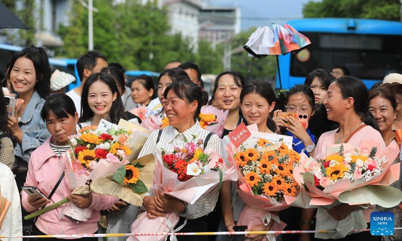 Family members of students wait outside a national college entrance examination site in Tengchong City, southwest China's Yunnan Province, June 8, 2024. 