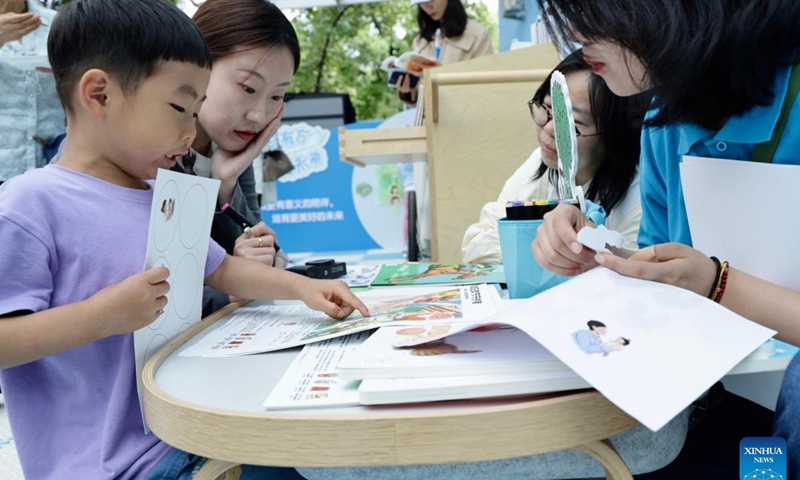 A mother and her son take part in a parents-child activity during a public campaign held in Beijing, capital of China, June 7, 2024.