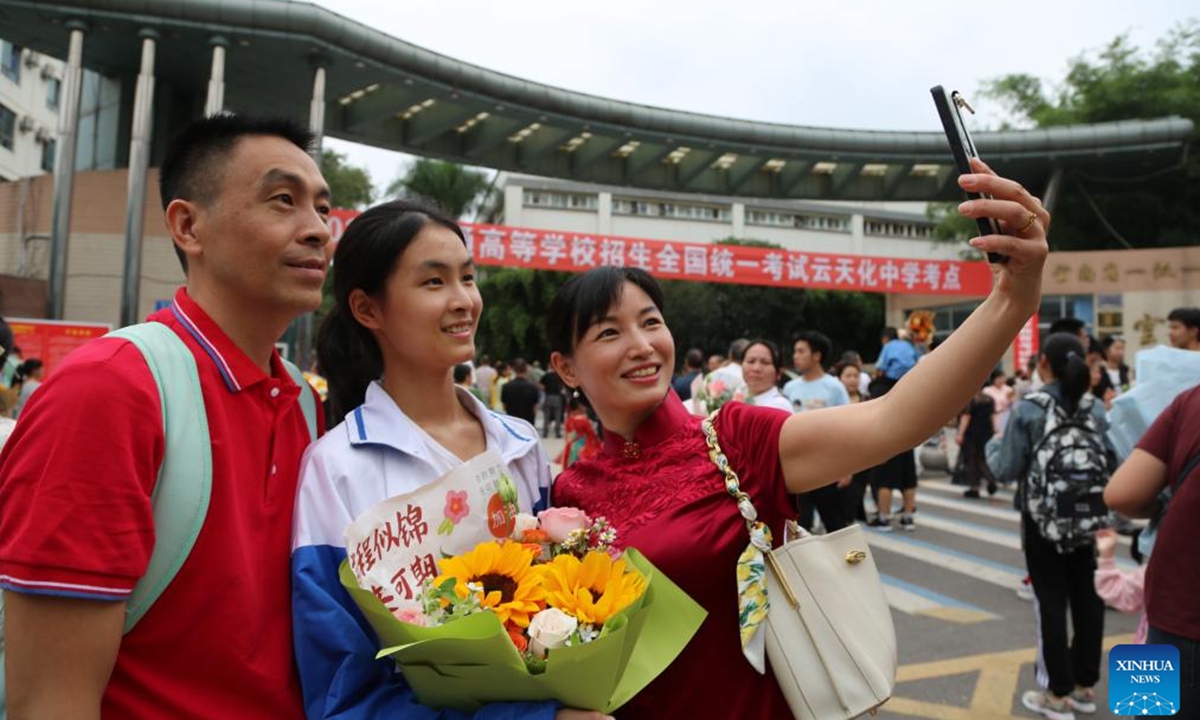 A family takes selfies outside a national college entrance examination site in Shuifu City, southwest China's Yunnan Province, June 8, 2024.