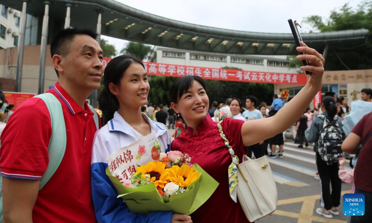 A family takes selfies outside a national college entrance examination site in Shuifu City, southwest China's Yunnan Province, June 8, 2024. China's annual national college entrance examination, also known as Gaokao, started on Friday. The exam in some regions has ended on Saturday. (Photo by Di Tingxiu/Xinhua)



