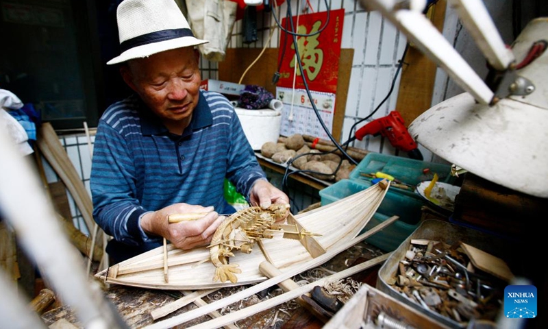 This file photo taken on April 24, 2017 shows Zhang Fucheng making a wooden dragon boat model in east China's Shanghai. (Photo: Xinhua)