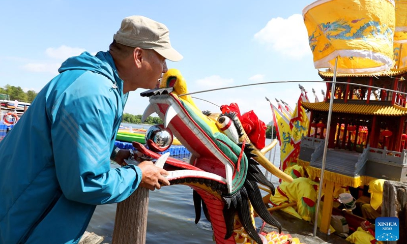 Zhang Guozhong assists his teammates to sail the dragon boat out of the dock during a rehearsal in Luodian Township, Baoshan District of east China's Shanghai, June 6, 2024.  (Photo: Xinhua)