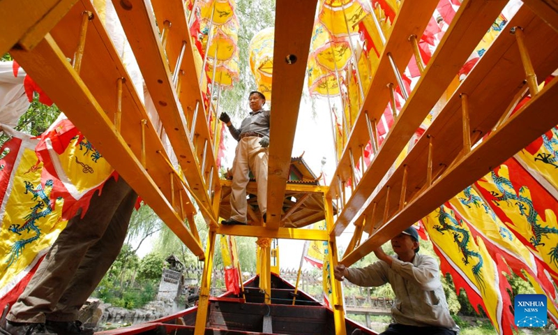 This file photo taken on May 25, 2017 shows Zhang Guomin (C) installing brackets in east China's Shanghai. (Photo: Xinhua)