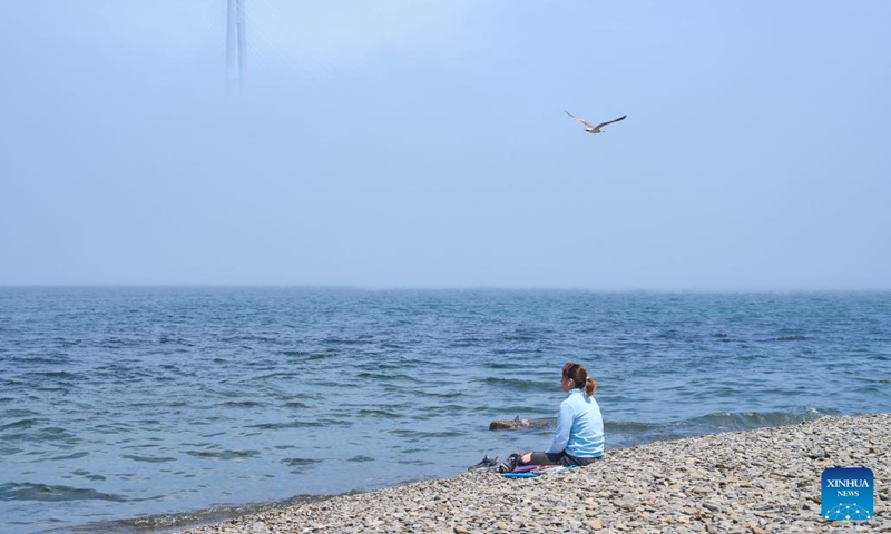 A woman looks at the Russky Bridge amid advection fog in Vladivostok, Russia, June 10, 2024.(Photo: Xinhua)