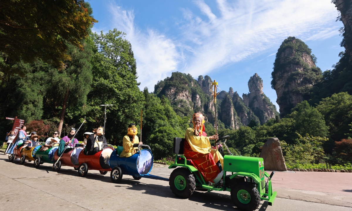 Staff members dressed as the main characters from  Journey to the West lead tourists on a ride on a 