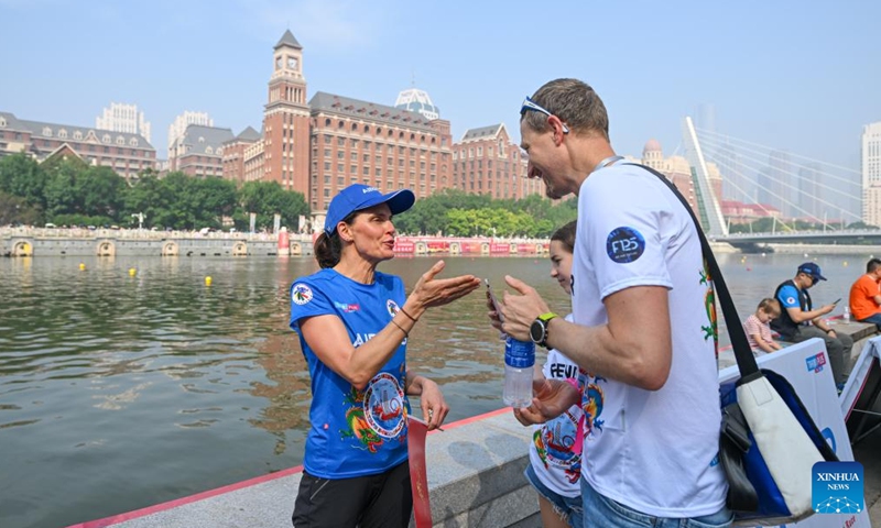 Laura Mora (L), a Spanish engineer from Airbus China, talks with her friend during the 2024 Haihe Dragon Boat Race in north China's Tianjin on June 10, 2024. (Photo: Xinhua)