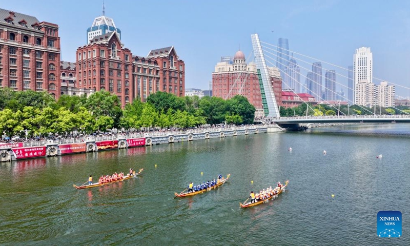 An aerial photo taken on June 10, 2024 shows Laura Mora, a Spanish engineer from Airbus China, and her teammates of Airbus China dragon boat team (in blue) compete in the 2024 Haihe Dragon Boat Race on the Haihe river in north China's Tianjin. (Photo: Xinhua)