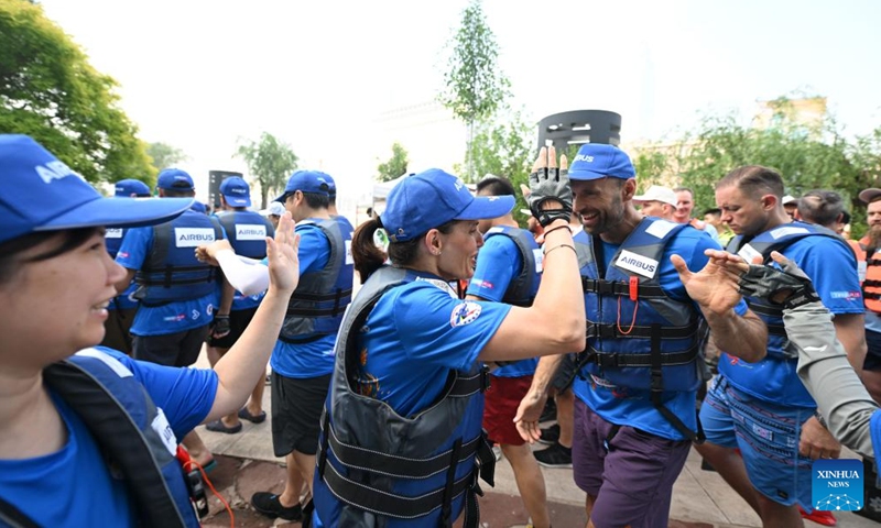 Laura Mora (front 2nd L), a Spanish engineer from Airbus China, greets teammates after preliminaries during the 2024 Haihe Dragon Boat Race in north China's Tianjin on June 10, 2024. (Photo: Xinhua)